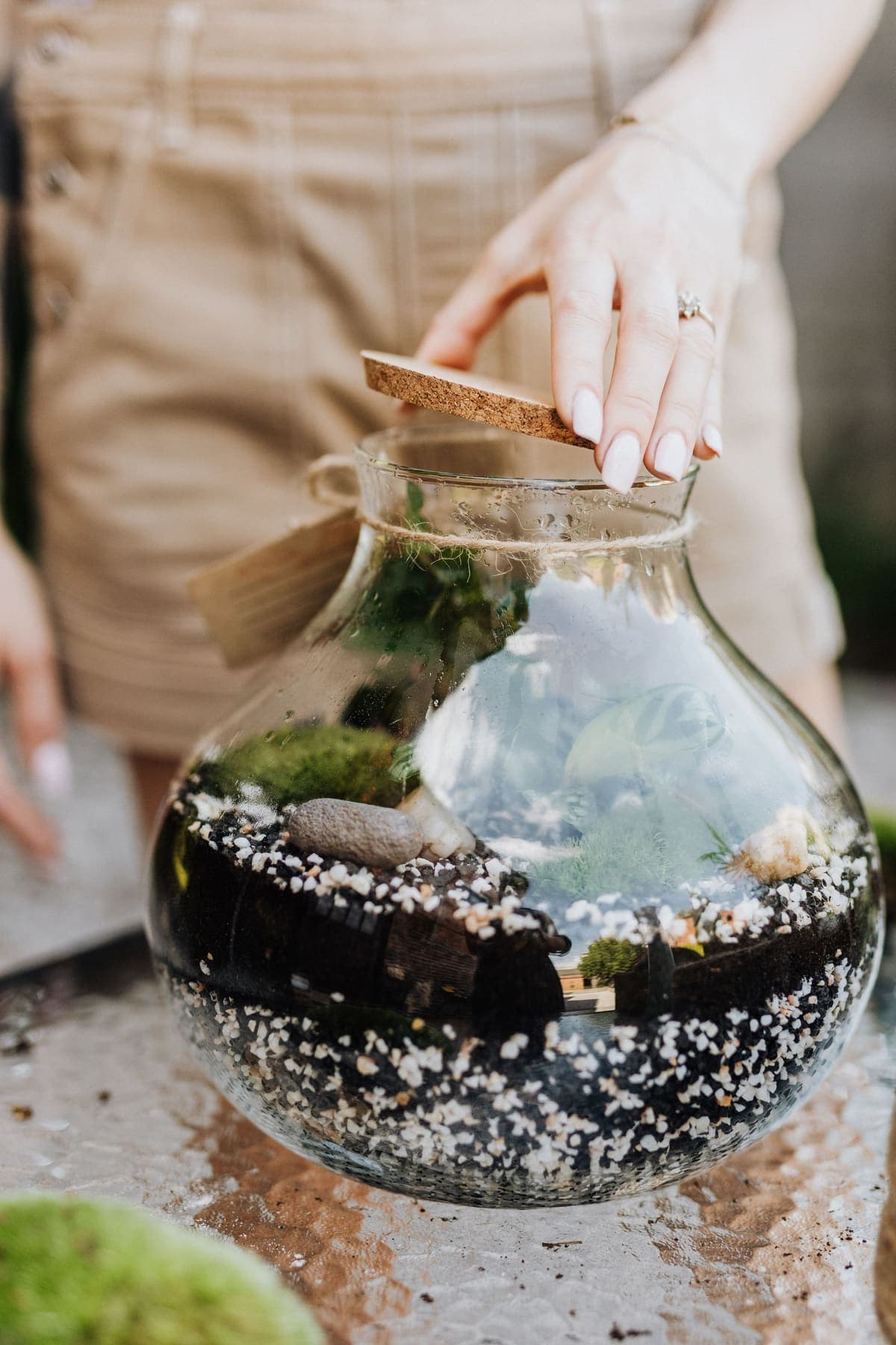 Mains refermant un terrarium avec un bouchon de liège