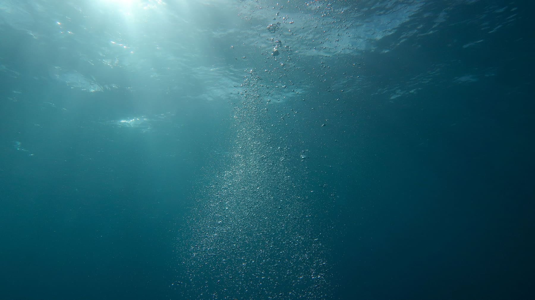 Lumière filtrant à travers l'eau et fines bulles